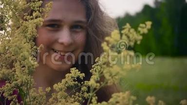 一个金发碧眼的年轻姑娘，<strong>手里</strong>拿着黄色，<strong>手里</strong>拿着黄色的野花。 动作缓慢。