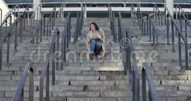 年轻迷人的高加索女人因为脚踝疼痛停在楼梯上。 年轻的女商人因为快速