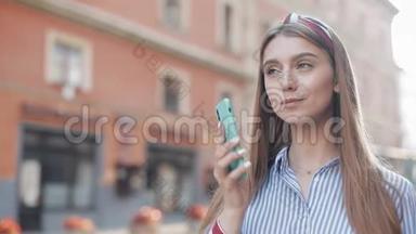 穿着条纹衬衫的年轻漂亮女孩在智能手机上拨打电话和打电话交谈和微笑