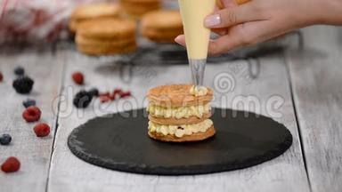 糕点厨师用奶油和浆果制作法国米尔·菲耶。 法式甜点，牛奶酥皮点心和奶油冻