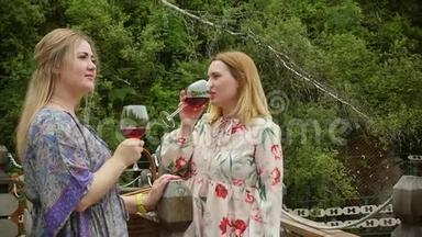 美丽<strong>优</strong>雅的女人喝着红酒，<strong>享</strong>受着在美丽的夏日花园里盛开牡丹的假期