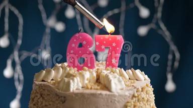 生日蛋糕有67个数字，由较轻的粉红色蜡烛燃烧在蓝色的背景上。 蜡烛<strong>被点燃</strong>了。 慢动作