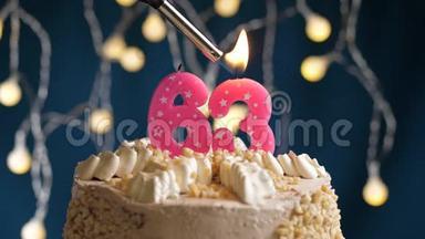 生日蛋糕，有63个数字，由较轻的粉红色蜡烛燃烧在蓝色的背景上。 蜡烛<strong>被点燃</strong>了。 慢动作