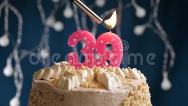 生日蛋糕，39个数字燃烧由较轻的粉红色<strong>蜡烛</strong>在蓝色的背景。 <strong>蜡烛</strong>被点燃了。 慢动作
