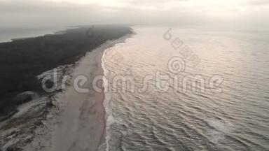 日落后蓝色小时的波罗的海海岸鸟瞰图。 暮光的海岸线带着滚滚的波浪，空旷的海滩
