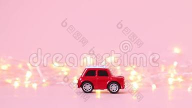 红色儿童`玩具车和一个金色闪烁花环在粉红色的背景。 假日概念