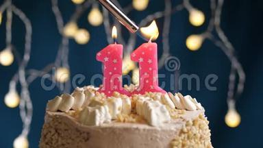 生日蛋糕，11个数字燃烧由较轻的粉红色<strong>蜡烛</strong>在蓝色的背景。 <strong>蜡烛</strong>被点燃了。 慢动作