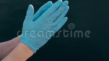 白种人的手<strong>戴</strong>着蓝色的医用<strong>手套</strong>。 黑色背景。 为<strong>医生</strong>准备手术，医疗程序。