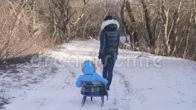 妈妈带着一个孩子坐在雪覆盖的森林上的雪橇上。 开朗的<strong>寒假</strong>观念..