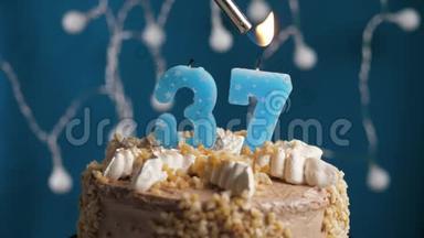 生日蛋糕，蓝色背景上有37支<strong>蜡烛</strong>。 <strong>蜡烛</strong>吹灭了。 慢动作和特写
