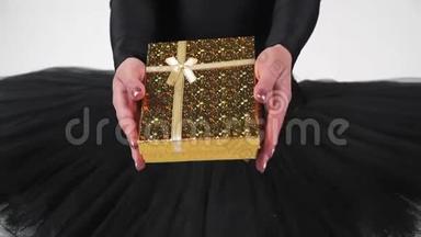 穿着黑色<strong>芭蕾舞</strong>裙的女<strong>芭蕾舞</strong>演员在一个漂亮的黄色盒子里拿出礼物。 慢<strong>动作</strong>