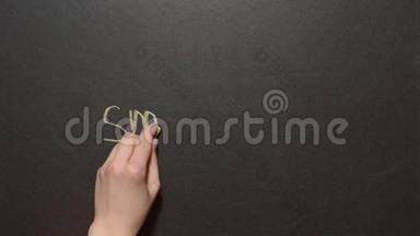 戒烟。 一只手用浅绿色粉笔在黑板上写字