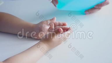 流行病期间，妈妈把液体肥皂倒在孩子的手掌上