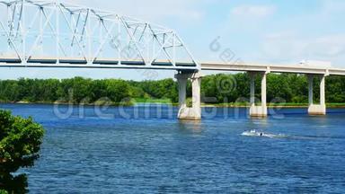 密西西比河在明尼苏达州和威斯康星州之间，上面有一座<strong>桁架</strong>桥，下面有一艘船，在一个阳光明媚的日子里。