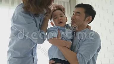 父母来安慰半日本男孩滑倒后，他的头被地板击中，直到他哭。 幸福的家庭和宝宝