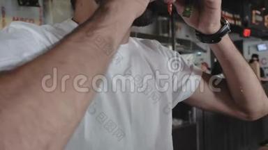 一个穿着白色T恤的家伙咬了一个汉堡，鸭子和番茄酱把他滴在白色T恤上。 男人吃汉堡包。 4k. 4k录像。