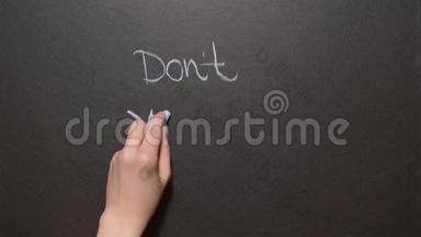 别担心`快乐。 一只手用粉笔<strong>在黑板上写字</strong>
