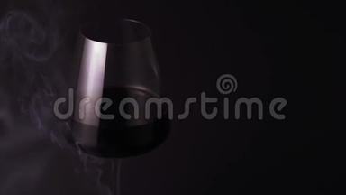 酒精和烟雾被隔离在黑色背景下，特写。 一杯特别漂亮的红酒