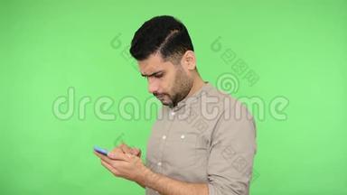 严肃细心的黑发男子，穿着衬衫，滚动社交媒体或在手机上阅读信息。