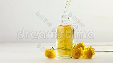 白色背景的黄色<strong>迷彩</strong>花在美丽的玻璃瓶中的精华