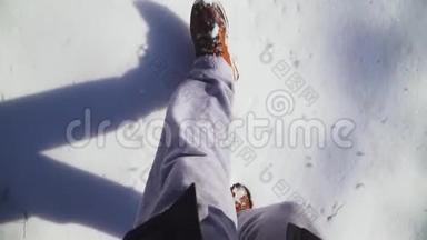 特写镜头。 男人穿着雪棕色的冬靴和灰色的运动裤。 雪，冬天的气氛.. 慢动作。 顶部视图