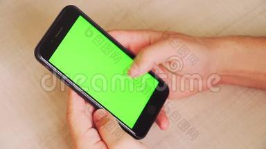 男人手里拿着智能手机，手里拿着绿色屏幕，手里拿着带有色度键的手机。 白色背景