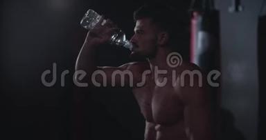 在交叉健身课上，<strong>身材好</strong>的运动员在紧张的锻炼后喝水非常渴，他有