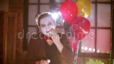 一个男人在<strong>更衣室</strong>镜子前的脸上涂着白色的油漆-背景上的气球
