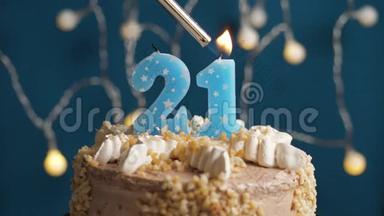 生日蛋糕，蓝色背景上有21支蜡烛。 蜡烛吹灭了。 慢动作和特写