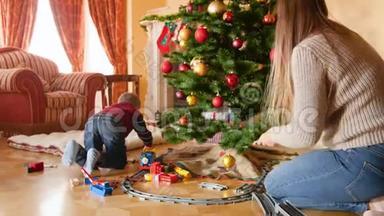 客厅<strong>圣诞树</strong>下幸福微笑家庭建造玩具铁路的4K<strong>视频</strong>。 接受礼物和礼物的儿童
