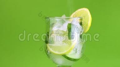 新鲜排毒<strong>饮料柠檬</strong>，薄荷，黄瓜，与<strong>冰</strong>在透明玻璃。 水倒入含有配料的玻璃中。 绿色