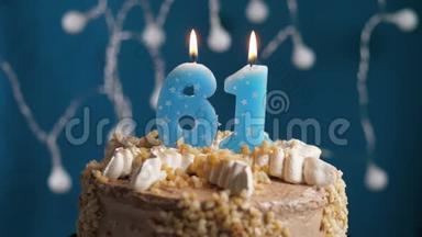 生日蛋糕，有61号<strong>蜡烛</strong>在蓝色的背景上。 <strong>蜡烛</strong>吹灭了。 慢动作和特写