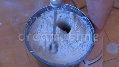 搅拌机搅拌水泥灰泥在桶内使用电动搅拌机，特写视图..