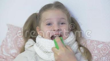 一个<strong>生病</strong>的<strong>小女孩</strong>被喷在她的嘴里，喉咙喷雾咳嗽，照顾孩子，感冒和病毒