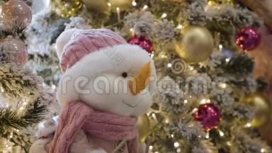 购物中心圣诞树上挂着微笑软玩具的特写。 可爱的小雪人在装饰之间