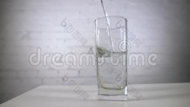 将新鲜<strong>矿泉水</strong>倒入桌子上的玻璃中。 白色背景带氧气球的新鲜起泡饮料