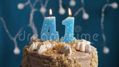 生日蛋糕，蓝色背景上有<strong>41</strong>支蜡烛。 蜡烛吹灭了。 慢动作和特写