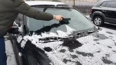 清理正在下雪的汽车。 冬天寒冷的早晨，黑车