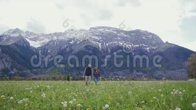 幸福的女人和男人牵着手走在美丽的山区。 好好休息。 一起去阿尔卑斯山旅行