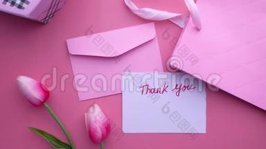 粉色背景的感谢信和礼品盒的俯视图