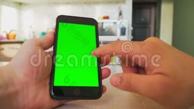 男人手里拿着智能手机，手里拿着绿色屏幕，手里拿着带有色度键的手机。
