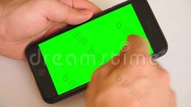 男人手里<strong>拿</strong>着智能手机，手里<strong>拿</strong>着绿色屏幕，手里<strong>拿</strong>着带有色度键的手机智能手机。 白色背景