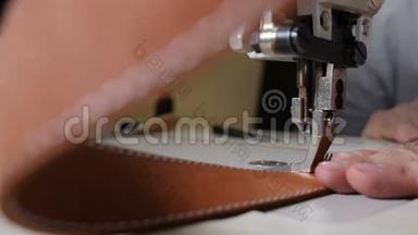 皮革制造中缝纫机的特写宏观视图，为皮带、<strong>袋子</strong>或<strong>钱</strong>包缝制皮革。 手工作坊