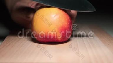 特写切片苹果.. 一个男人在厨房的砧板上切红苹果