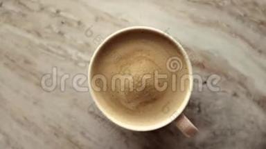早晨的咖啡杯，牛奶放在大理石石板上，热饮放在桌子上，上面有食物录像和食谱