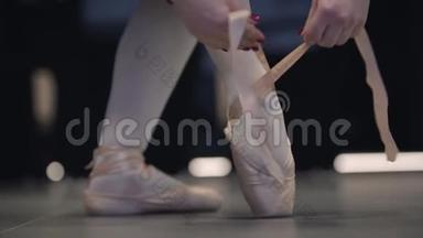 缓慢的动作优雅的不可辨认的白种人芭蕾舞者绑着点。 优雅的女芭蕾舞演员穿上芭蕾