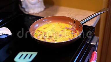一份美味的早餐煎锅，上面有火腿、鸡蛋、新鲜蔬菜和融化的奶酪。 鸡蛋是在这个剪辑中添加的。
