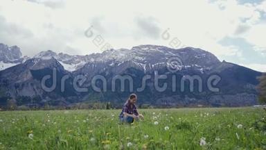 年轻女子在山上背景下尝试蒲公英花环。 总计划。 风景山水景观