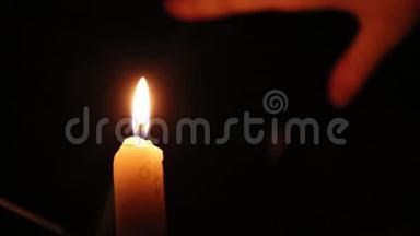 一支美丽的蜡烛在黑暗的房间里燃烧，一支温暖的黄色蜡烛在黑暗中静静地燃烧。