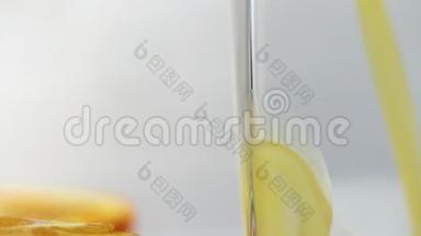 鲜榨的橙汁倒在桌子上的玻璃杯里，旁边放着几片橘子。 新鲜黄色饮料